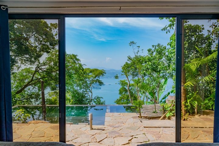 Terraza de piedra con piscina y vista al lago